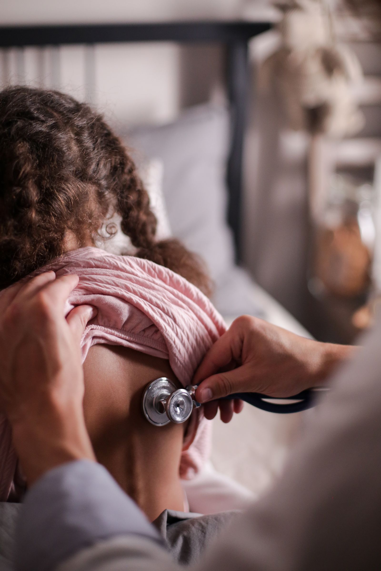 A doctor listening to a child's back
